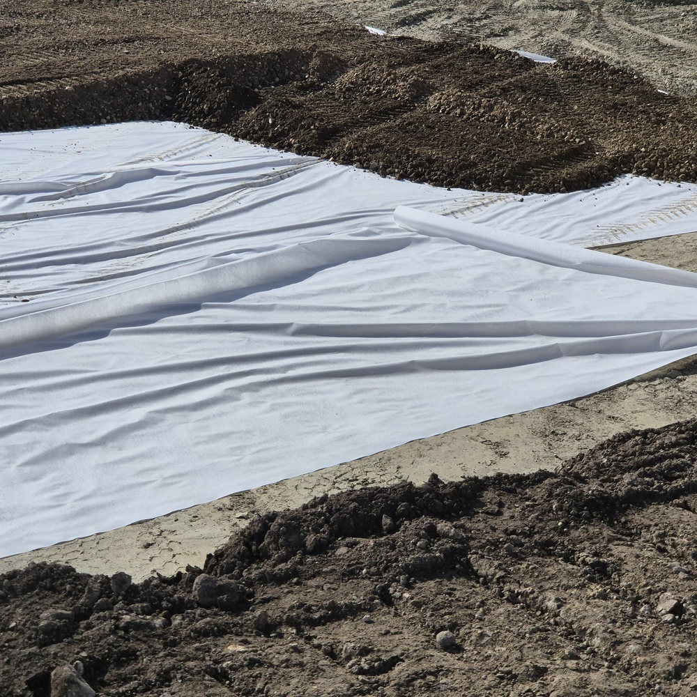 Geotextile fabric laid over prepared soil at a stabilization site